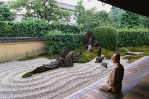 Monk Meditating by Zen Rock Garden